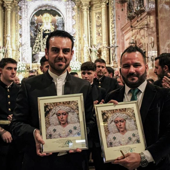 Manu Guerrero junto a otro músico con placas conmemorativas ante el altar