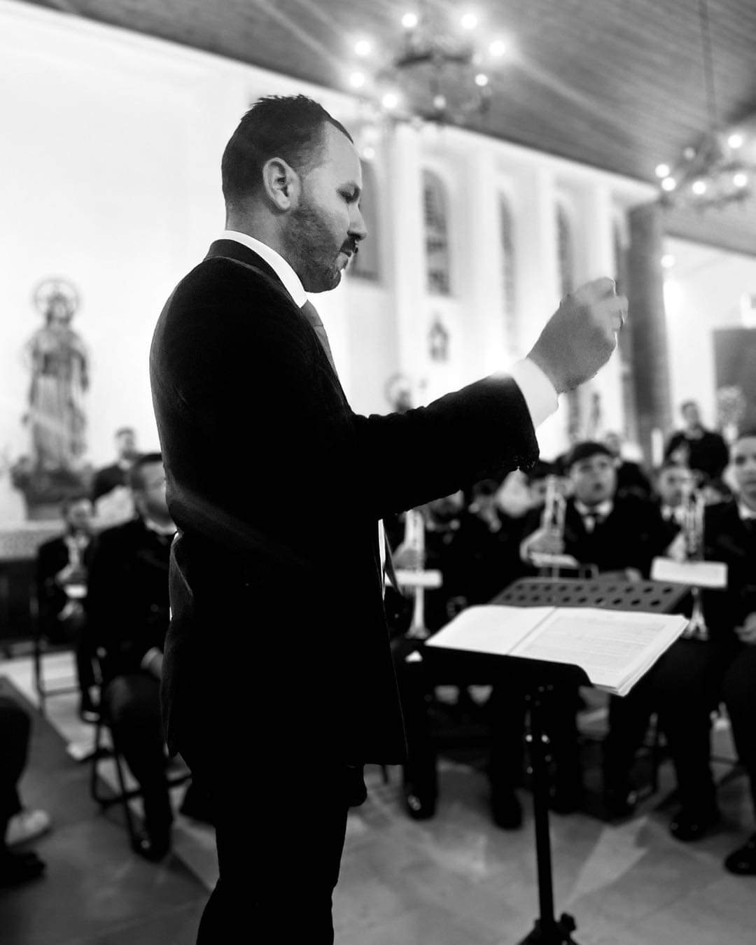 Manu Guerrero dirigiendo una banda de cornetas y tambores en el interior de un templo