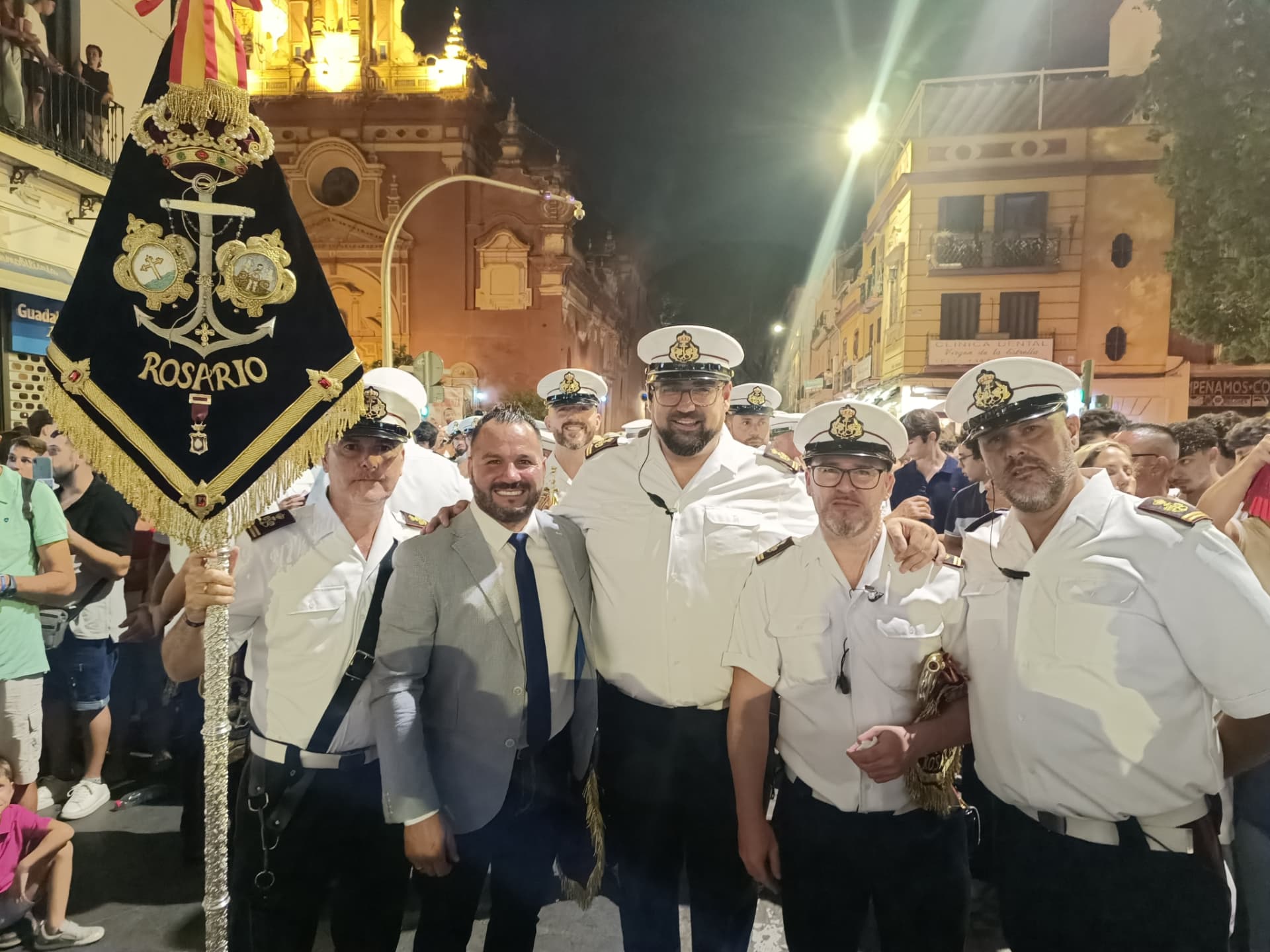 Manu Guerrero junto a la directiva de la banda del Rosario ante el estandarte en Sevilla
