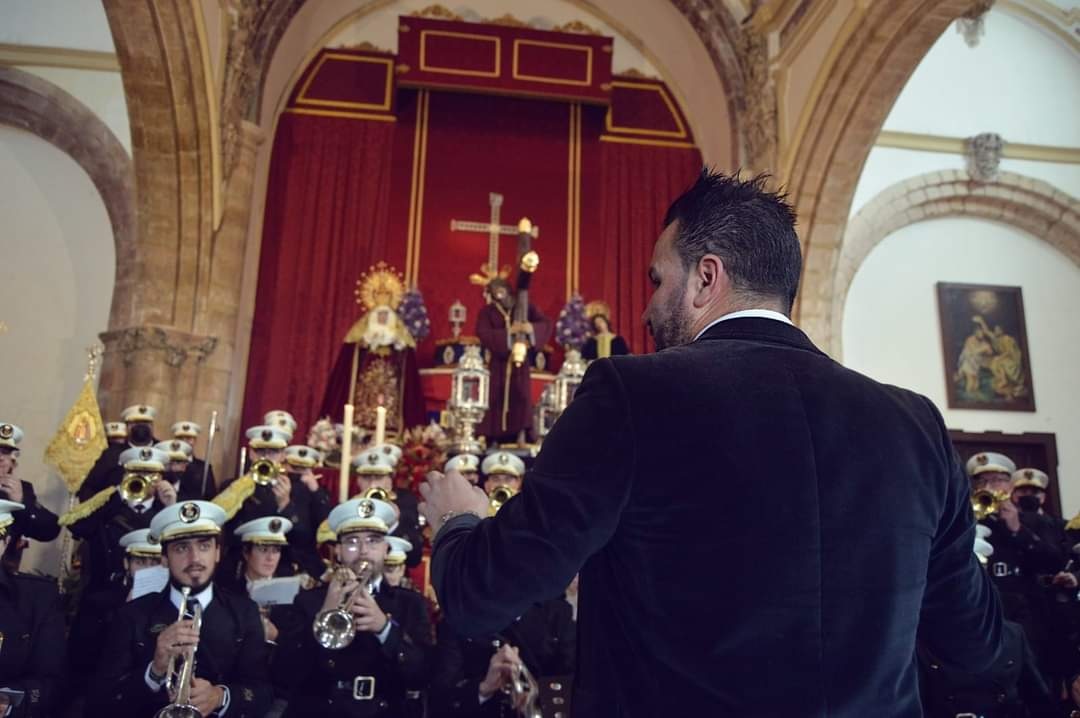 Dirección de espaldas ante el paso del Cristo en un templo