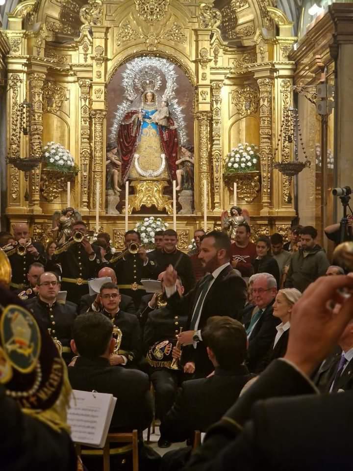 Manu Guerrero dirigiendo ante el retablo dorado de la Virgen
