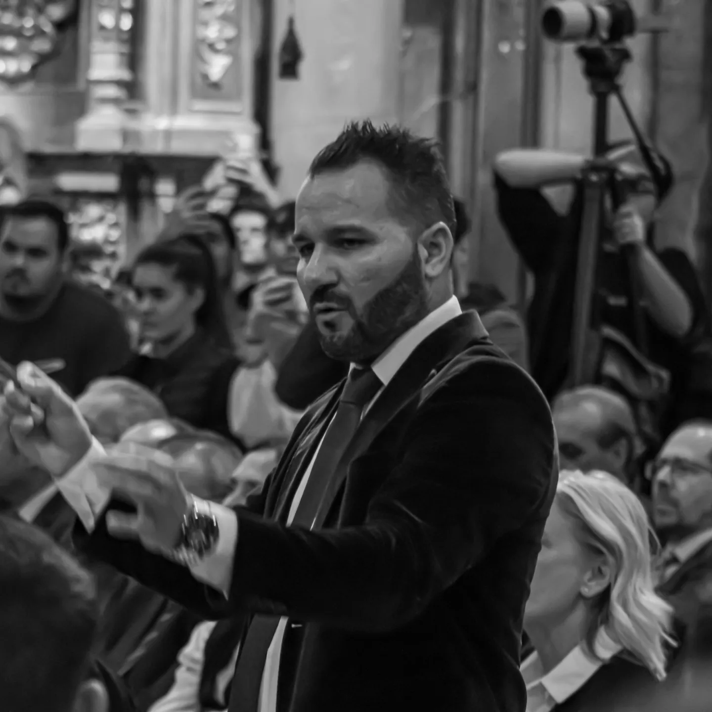 Manu Guerrero dirigiendo rodeado de público y cámaras